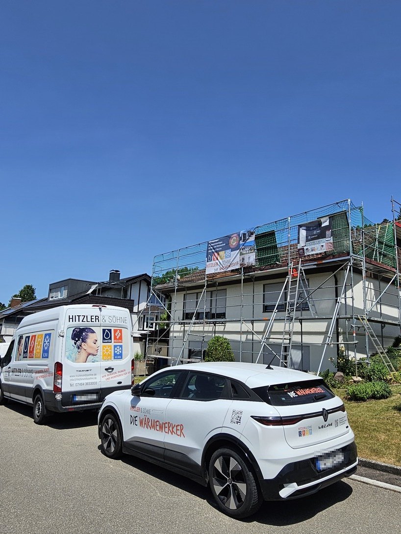 Fahrzeuge der WärmeWerker vor dem eingerüsteten Haus der PVT-Referenz Dolata