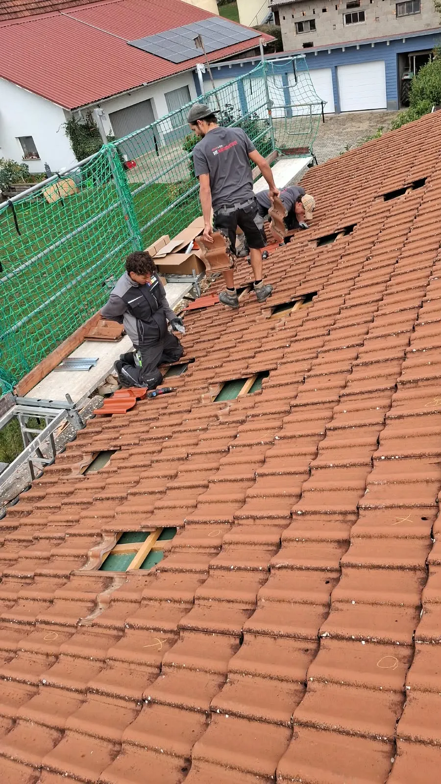Referenz Neuhausen ob Eck: Dachmontage vom Gerüst mit Fangnetz: Ziegel werden für die Dachhaken geöffnet